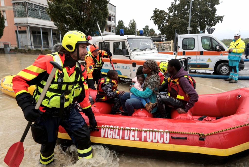 Voluntarios de Protección Civil y bomberos ayudan a las víctimas de las inundaciones que fueron desalojadas de una zona inundada en vía Cimatti, en la ciudad de Faenza, región de Emilia-Romaña, norte de Italia