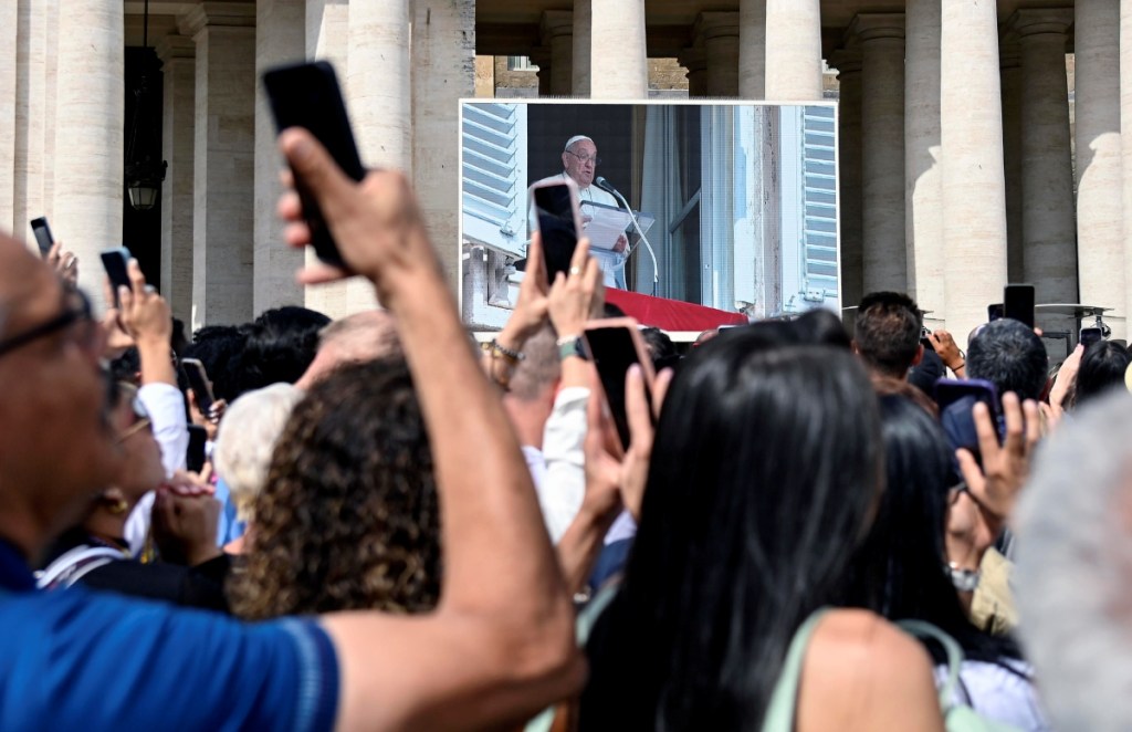 Feligreses escuchan al papa Francisco durante la meditación del Ángelus, ayer en la Plaza de San Pedro