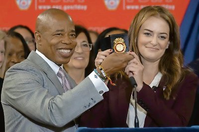 La comisionada de bomberos Laura Kavanagh y el alcalde de Nueva York, Eric Adams, sostienen una placa del Departamento de Bomberos