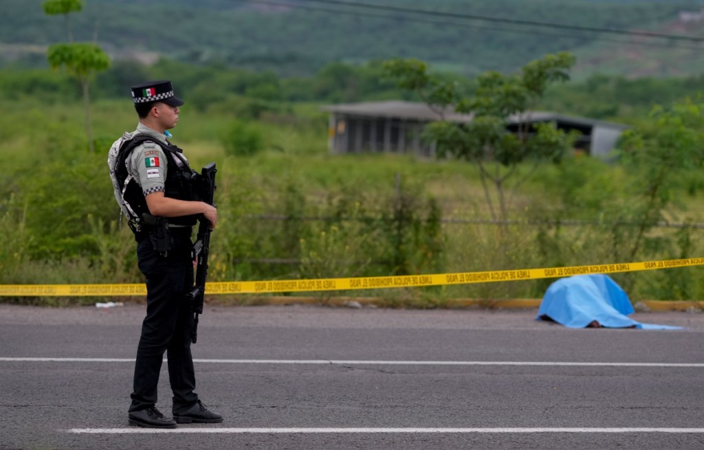 Un elemento de la Guardia Nacional Mexicana vigila junto a un cuerpo encontrado en una vía de Culiacán, anteayer sábado