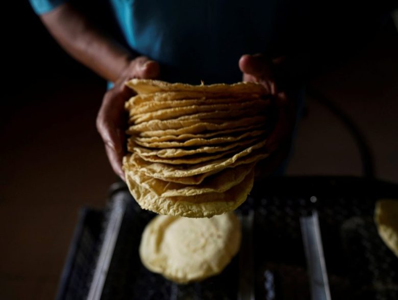 Un trabajador acomoda tortillas recién hechas antes de envolverlas para vender, en un expendio de una colonia de Ciudad de México