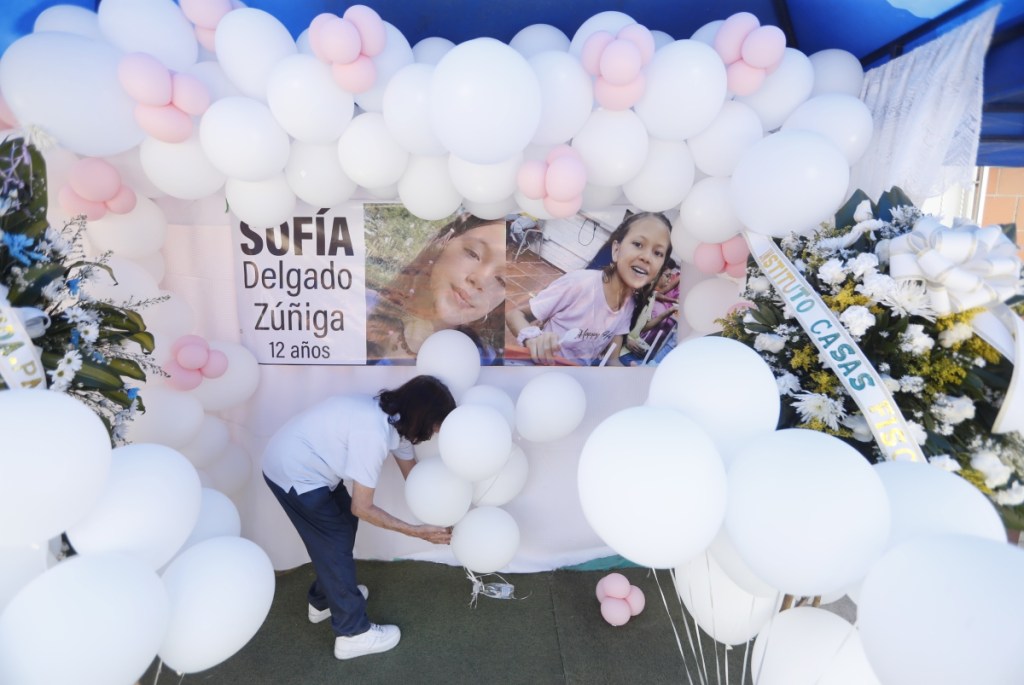 Una niña coloca globos junto a una ofrenda a Sofía Delgado Zúñiga, en la casa en dónde la infortunada menor vivía, en Candelaria, Colombia