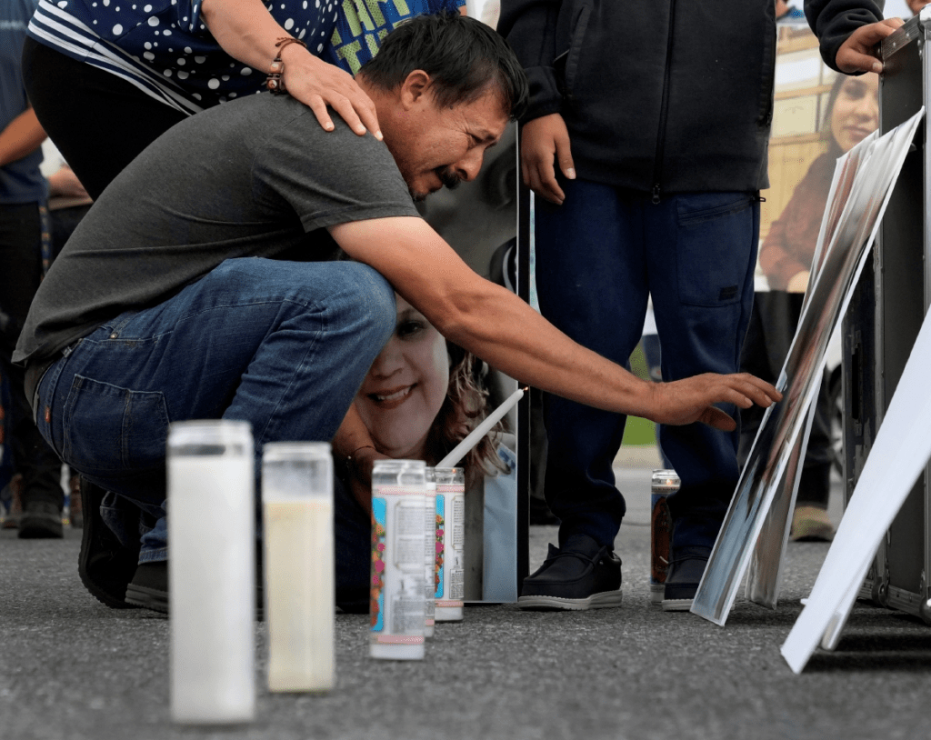 Un migrante se inclina para tocar la fotografía de su esposa, quien falleció en una planta durante una inundación provocada por el huracán “Helene” en Erwin, Tennessee