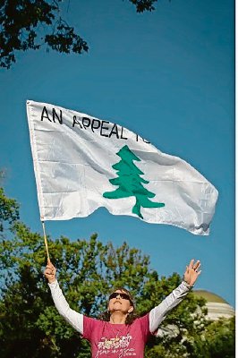 El pastor conservador Lou Engle habla durante la manifestación “Un Millón de Mujeres” en el National Mall en Washington, ayer. A la izquierda, Susan Marsh, de Maryland, reza mientras sostiene una bandera de la organización “Appeal to Heaven” durante el evento