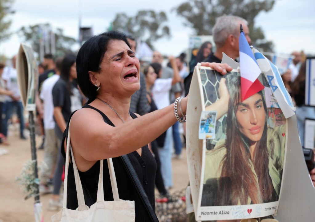 Arriba, una activista sostiene una pancarta durante una manifestación de apoyo al pueblo palestino en Skopje, República de Macedonia del Norte. Abajo, un palestino inspecciona los escombros de la destruida Mezquita de los Mártires de Al Aqsa, tras un ataque israelí en Gaza