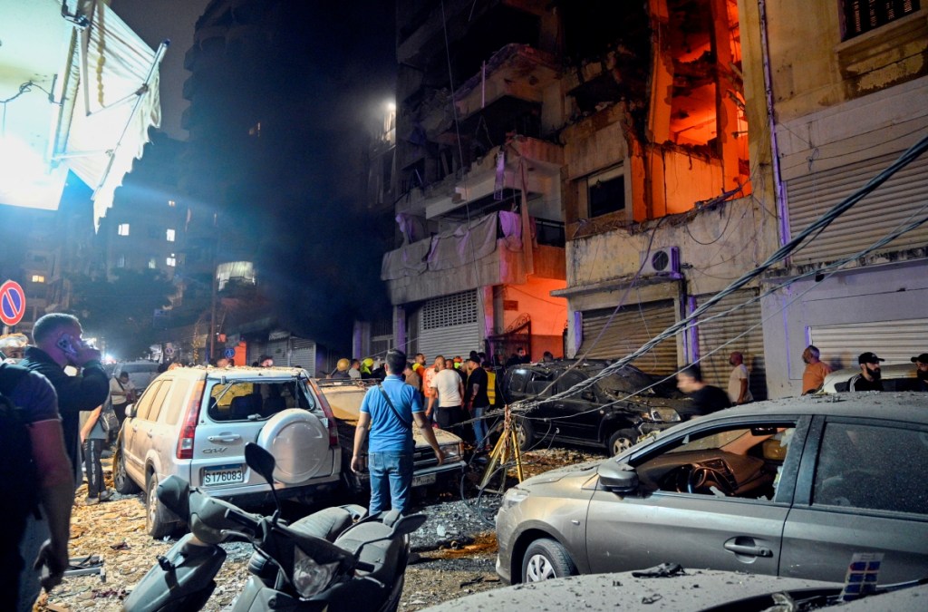 Una mujer palestina llora a sus familiares que murieron en un ataque aéreo israelí contra la escuela Rufaida, en Deir al-Balah, en el centro de la Franja de Gaza. A la izquierda, edificio destruido en un ataque israelí en Beirut