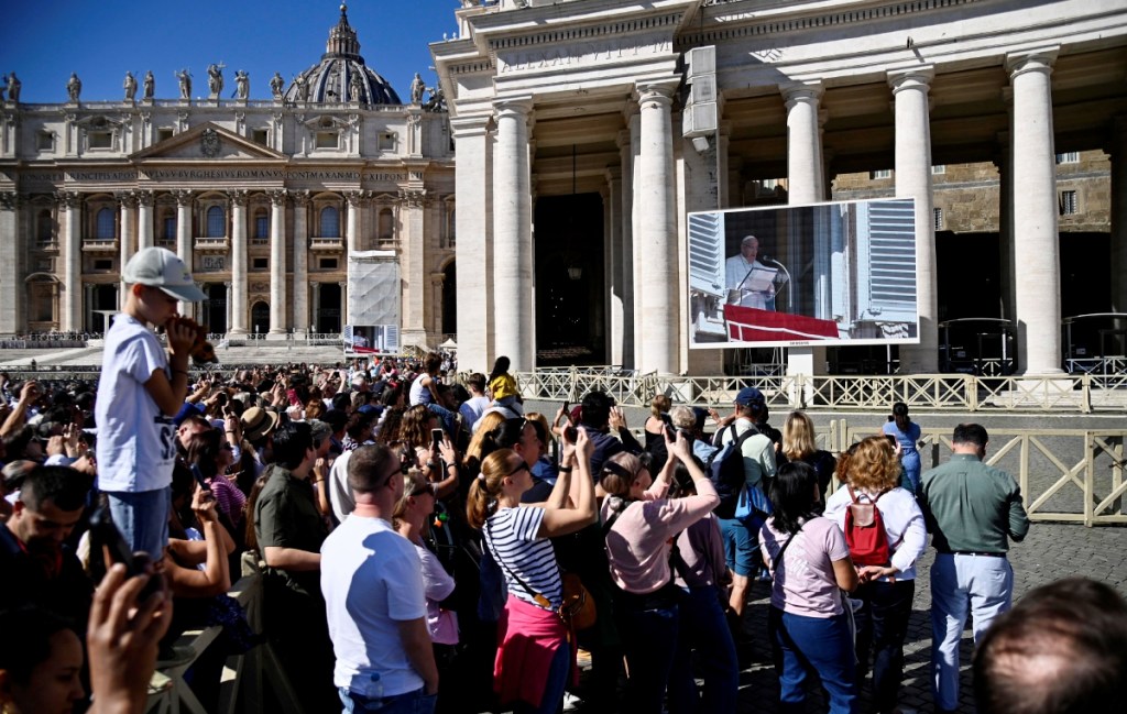 Feligreses escuchan el rezo del Ángelus que dirigió el papa Francisco desde la ventana de su despacho