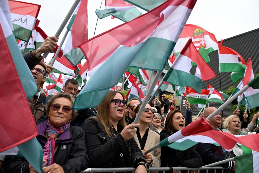 Participantes en la marcha en Budapest ondean banderas de Hungría durante una manifestación organizada por el partido opositor Tisza