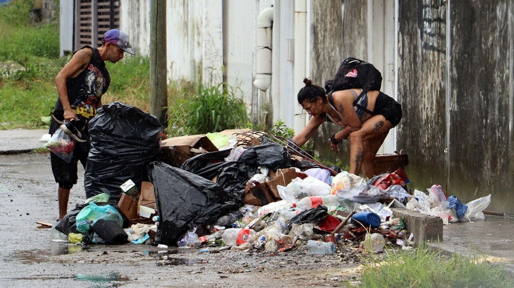 Dos personas buscan entre la basura en Tapachula, Chiapas, donde líderes religiosos y migrantes pidieron al nuevo gobierno de México una frontera sur fraterna, no militarizada (Foto de EFE)