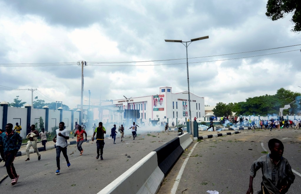 Manifestantes huyen de gases lacrimógenos durante una protesta en la calle en Kano, Nigeria, el 1 de agosto