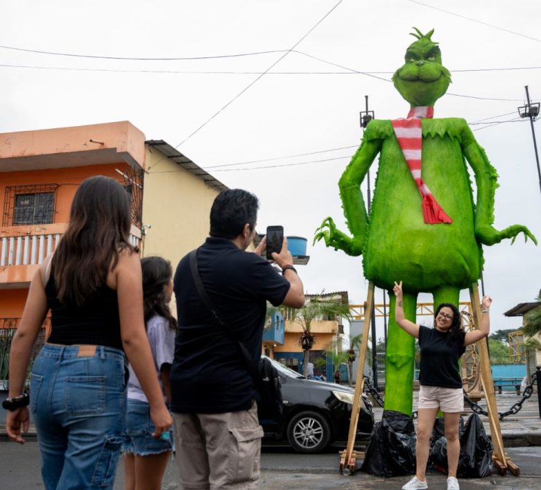 Monigotes de “Furia” y “Tristeza”, personajes de la película “Intensamente”, listos para ser incinerados. A la izquierda, visitantes posan con la figura de “El Grinch”. Los propietarios de las figuras, en cuya fabricación realizan una inversión sobrepasa los 1,000 dólares, también suelen cobrar a los visitantes por las fotos que se toman