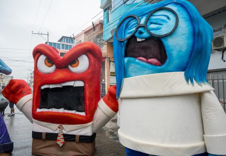 Muñeco de los personajes de “Garfield” y “Jon Bonachón”, en el punto de la ciudad de Guayaquil donde serán quemados esta noche. A la izquierda, Charles Vilema, presidente de la Asociación de Artistas de Monigotes Gigantes, posa con un personaje de la película “Intensamente”