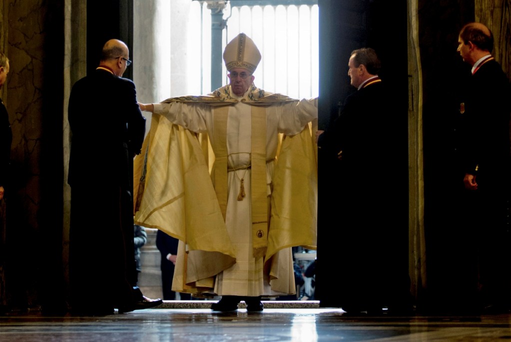 El papa Francisco abre la Puerta Santa de la Basílica de San Pedro en el Vaticano, el 8 de diciembre de 2015. A la derecha, una religiosa levanta un Niño Dios durante el rezo del Ángelus en la Plaza de San Pedro, anteayer, en la tradicional bendición de estatuillas que se realiza cada tercer domingo de adviento