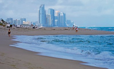 Visitantes caminan en la playa de Surfside, cerca del hotel Sunny Isles Beach, zona incluida en el estudio de la Escuela Rosenstiel de Ciencias Marinas, Atmosféricas y Terrestres de la Universidad de Miami