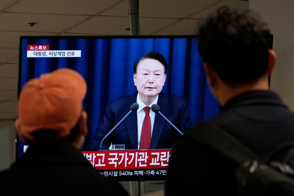 Personas ven un televisor con la imagen del presidente Yoon Suk-yeol, quien anunció ley marcial en Corea del Sur (foto de AP)