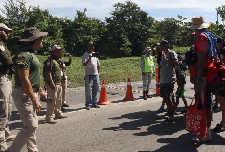 Personal del Instituto Nacional de Migración (INM) conversa con migrantes de una caravana en el municipio de Huixtla, Chiapas, para tratar de convencerlos de que sigan avanzando hacia el norte. El contingente con más de 1,500 migrantes que partió esta semana de Tapachula, al igual que otros grupos similares, se toparon con el bloqueo de las autoridades mexicanas, quienes tratan de impedir que salgan del estado de Chiapas