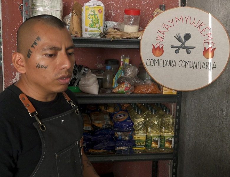 El fundador del comedor comunitario “Comamos Todos”, Filadelfo Aldaz Desiderio, habla en una entrevista el lunes, en la ciudad de Oaxaca. A la derecha, indocumentados reciben alimentos como parte de la iniciativa de comunidades indígenas de esa ciudad, lideradas por Filadelfo