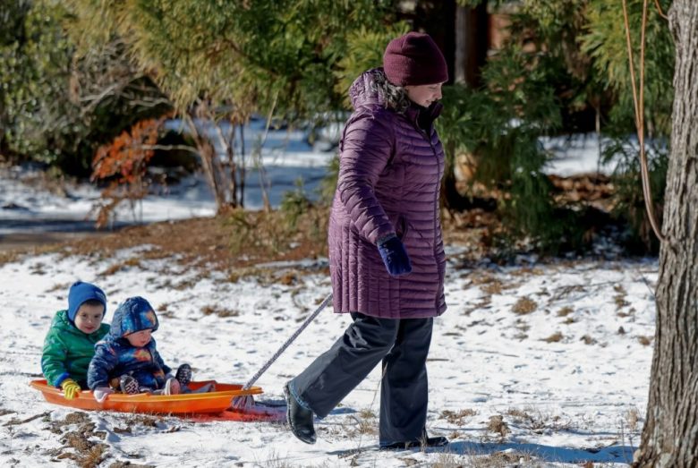 Una madre jala a sus dos hijos en un trineo después de que cayeron al menos 12 milímetros de nieve en el área metropolitana de Atlanta, incluida la comunidad de Avondale Estates, en el condado DeKalb