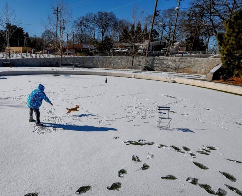 Un hombre pasea por calles de Nueva Orleans. A la izquierda, autos que quedaron atascados en la nieve en la misma ciudad de Luisiana. La tormenta invernal obligó a suspender las clases en la zona