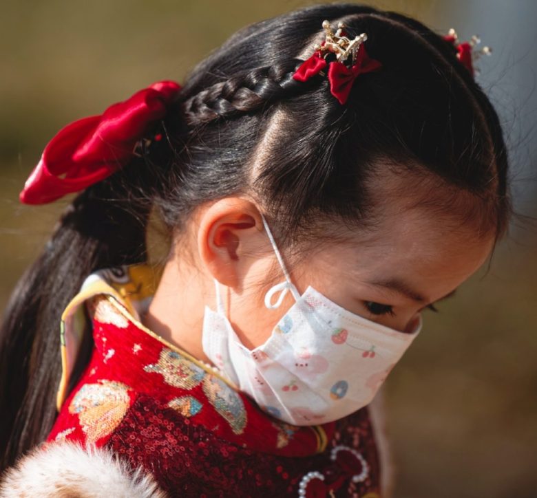 Una niña con cubrebocas camina por un parque en Wuhan, provincia de Hubei, China. El jueves 23 pasado se cumplió el quinto aniversario del confinamiento de 76 días de Wuhan por la pandemia del Covid-19