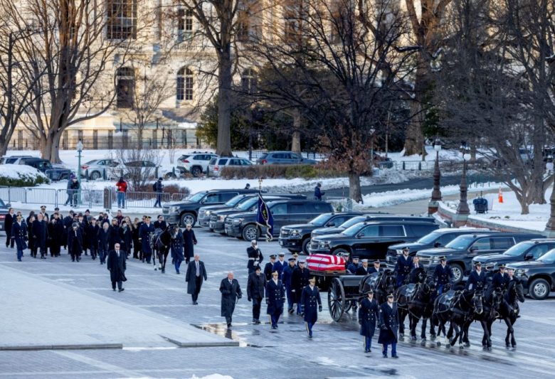 La llegada del ataúd del expresidente Carter al Capitolio en Washington. A la derecha, una guardia militar en su honor