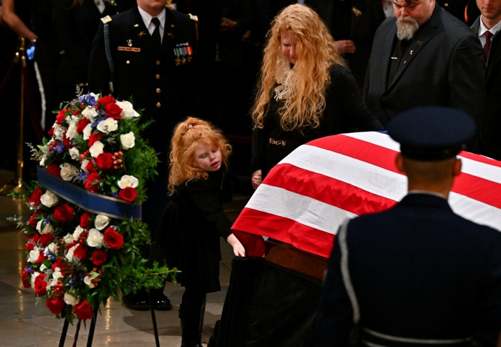 Una niña toca el ataúd del expresidente Jimmy Carter durante una ceremonia en la rotonda del Capitolio de EE.UU. en Washington