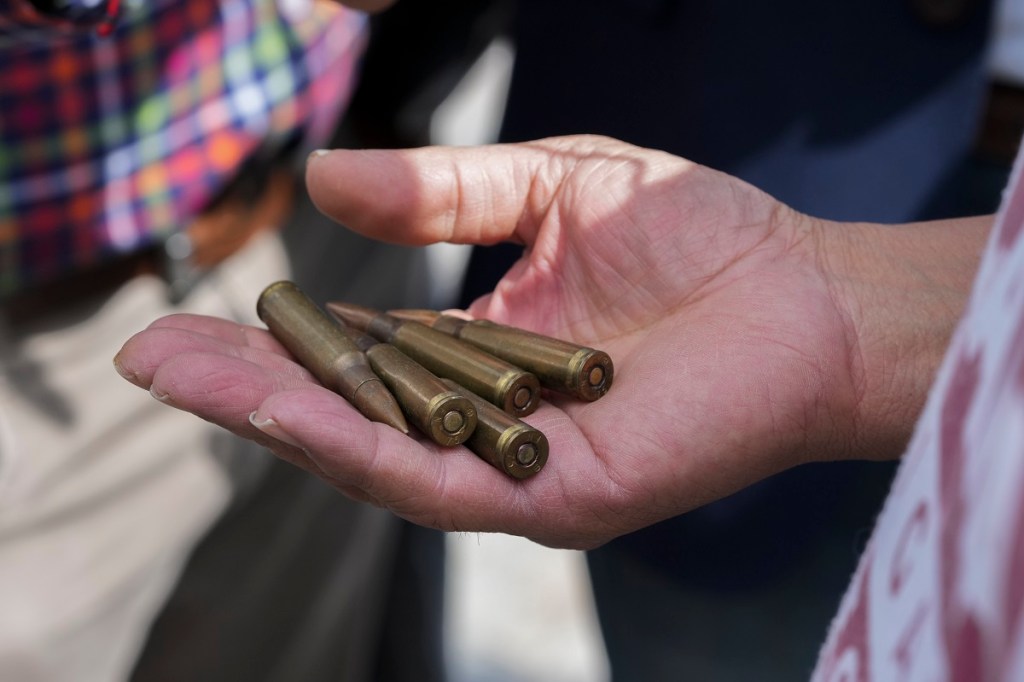 Un hombre muestra balas para canjear por dinero en efectivo como parte del programa "Sí al Desarme, Sí a la Paz"(Foto de AP)