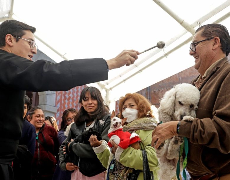 Una mujer carga a su mascota ayer viernes, en la ciudad de Puebla. Miles de feligreses mexicanos llevaron a sus mascotas a la iglesia para que reciban la bendición este día de San Antonio Abad, patrono de los animales, para que tengan una “protección divina”