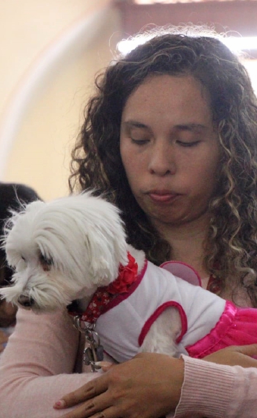 Una devota ora con su mascota recién bendecida, en Puebla