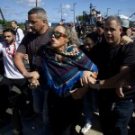 Seguidores del senador independiente puertorriqueño Eliezer Molina son detenidos ayer, antes de la ceremonia. A la derecha, la gobernadora Jenniffer González, y su esposo, José Jovin Vargas, rezan en la iglesia de las Siervas de María, en San Juan, ayer antes del acto protocolario