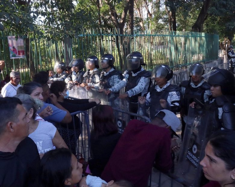 Miembros de la Guardia Nacional (GN) resguardan una estación migratoria en Tapachula, donde numerosos migrantes se agolpan ante las nuevas medidas de EE.UU.