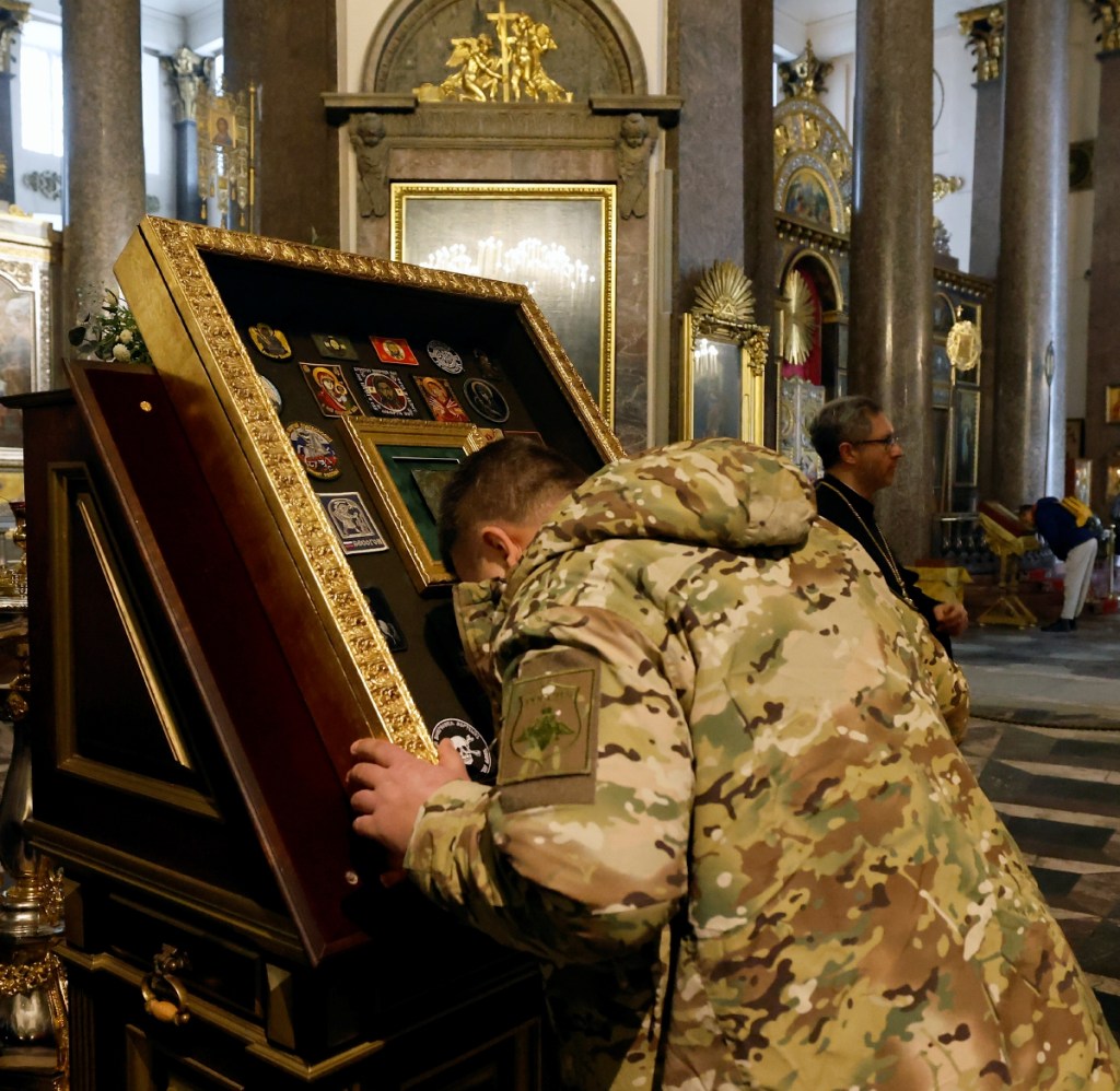 Un militar besa una vitrina de iconos en a la Catedral de Kazán en San Petersburgo, Rusia, ayer