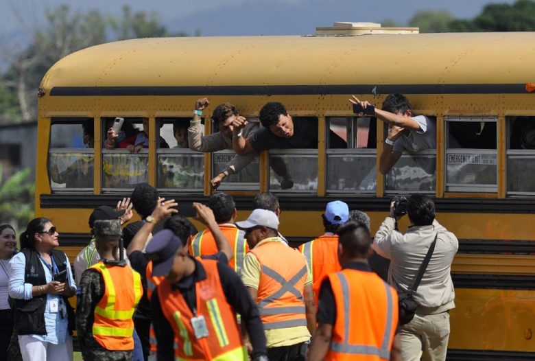 Personas deportadas son transportadas en un autobús a su llegada a la base aérea Armando Escalon ubicada en San Pedro Sula