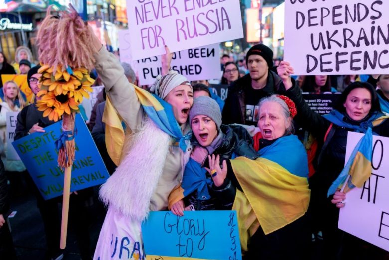 Manifestantes cantan el himno nacional de Ucrania durante una concentración en respaldo a esa nación, ayer en Times Square, Nueva York