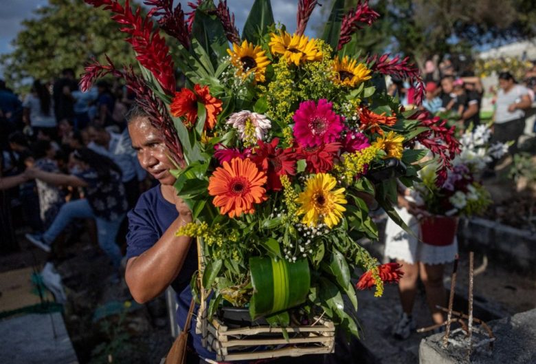 Una mujer lleva un arreglo floral en el cementerio de Santo Domingo de Los Ocotes, donde ayer se llevó al cabo el entierro de algunas víctimas del accidente de transito que enlutó a la comunidad