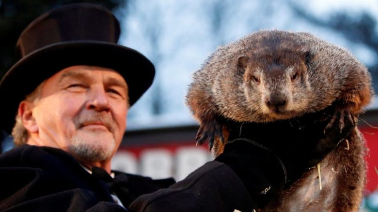 A la izquierda, asistentes al evento en que la marmota Phil, según la tradición, indica si seguirá el invierno, en Punxsutawney, Pensilvania. La famosa marmota “pronosticó” que el invierno será más largo de lo esperado en EE.UU., puesto que el roedor vio su sombra al salir de la madriguera, lo que indica que esa estación durará 6 semanas más