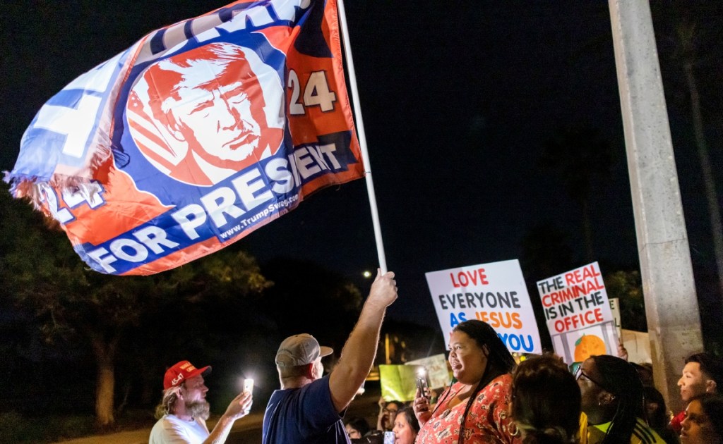 Partidarios de Donald Trump y manifestantes contra sus recientes políticas discuten durante una protesta en Lake Worth Beach, Florida, anoche