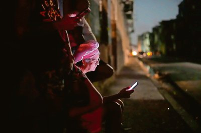 Una mujer consulta su celular durante el apagón, anoche en La Habana