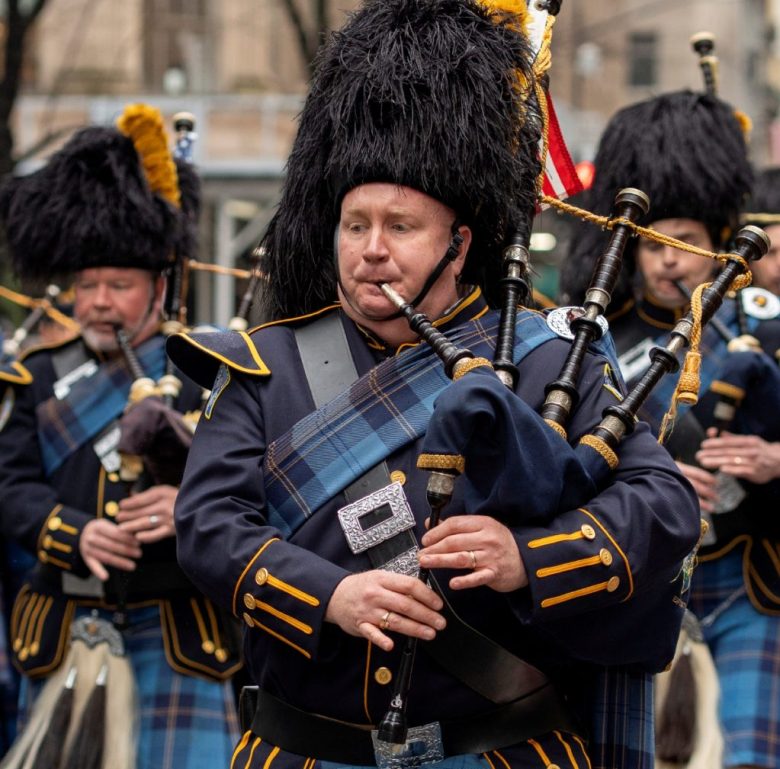 Un grupo de asistentes al desfile de San Patricio en la Quinta Avenida de Manhattan, en Nueva York. A la izquierda, una pareja posa sonriente para la cámara en el mismo desfile, ayer lunes