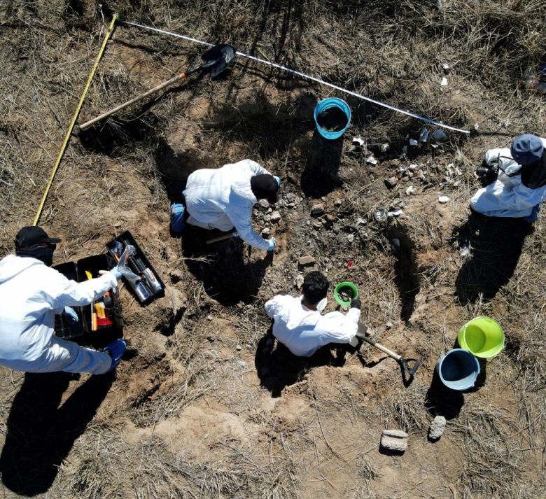 Personal forense excava en un sitio de exterminio de un cártel, donde había restos humanos enterrados, a las afueras de Nuevo Laredo (2022)