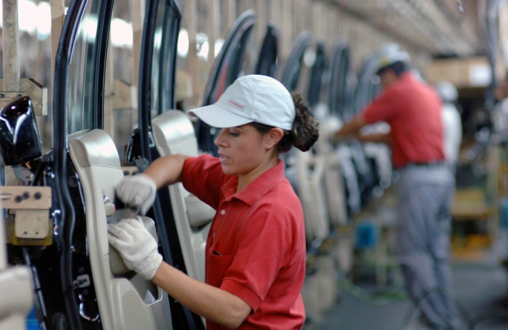 Trabajadores ensamblan vehículos en México, mientras la industria afronta incertidumbre por gravamen