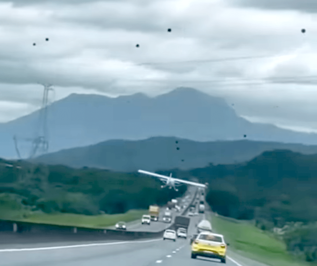 avioneta aterriza entre automóviles