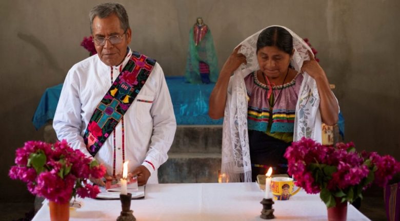 El diácono Juan Pérez Gómez transporta hostias consagradas para repartir durante la Comunión en una celebración litúrgica, en el municipio de Simojovel, Chiapas. A la derecha, con su esposa, Crecencia López, quien lo apoya en su labor pastoral y en la catequesis