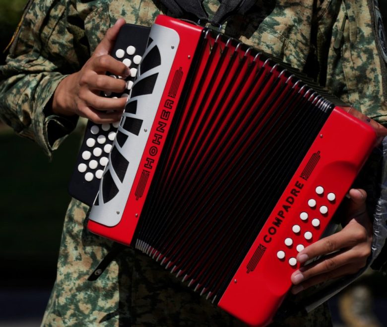 El vocalista Eduin Caz, del grupo regional mexicano Grupo Firme, durante un concierto gratuito en el Zócalo. A la izquierda, Natanael Cano, en el festival AXE Ceremonia en el Parque Bicentenario. Debajo, un soldado interpreta un corrido para los medios en una base militar en CDMX