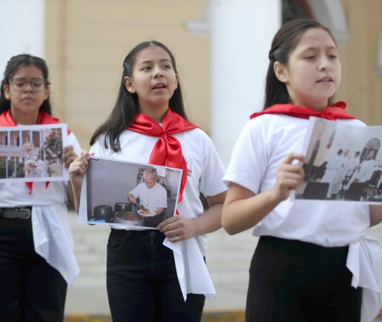 Niñas con fotos del papa León XIV cuando era obispo de Chiclayo, cantan canciones frente a la iglesia Santa María Catedral de Chiclayo, sede de la diócesis que presidió