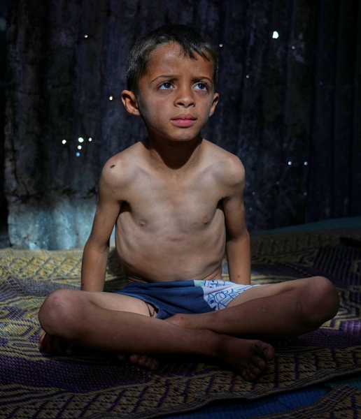 Niños palestinos intentan conseguir comida donada en una cocina comunitaria, en Jan Yunis, Franja de Gaza, donde la situación empeora por el bloqueo israelí a la ayuda