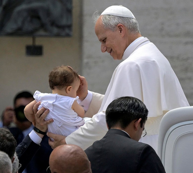 Una religiosa con una imagen de la Virgen de Schoenstatt, ayer en la Plaza de San Pedro. Abajo, el papa León XIV bendice a un niño