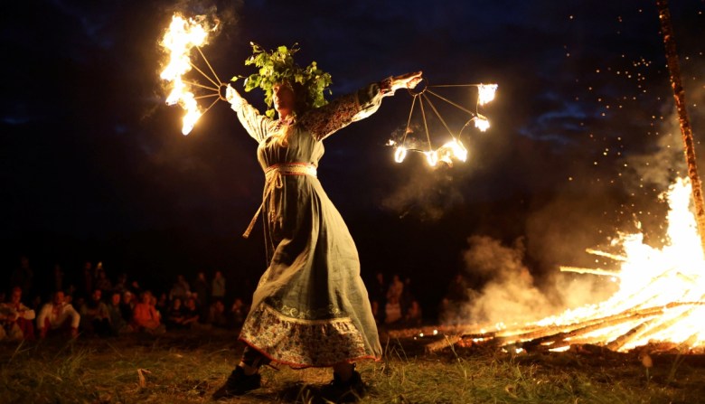 Personas asisten al solsticio de verano en Stonehenge, Wiltshire, Gran Bretaña. A la derecha, una mujer con corona de flores baila en un evento inspirado en tradiciones precristianas, en las que hadas, llamadas “Sanziene” en rumano, bajan a la Tierra en el solsticio de verano, en Bucarest