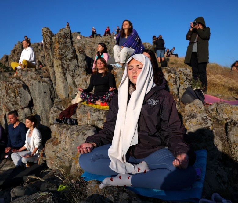 KUMANOVO (Republic of North Macedonia), 21/06/2025.- People practice yoga as the sun rises during the Summer Solstice atop a rocky crest filled with astronomical stone markers at the ancient megalithic observatory of Kokino, North Macedonia, early 21 June 2025. The observatory located about 80 km north-east of Skopje, uses the method of stationary observation, marking positions of the sun at the winter and summer solstice, as well as the equinox, and dates back more than 4000 years ago. Kokino was nominated to be included on UNESCO's World Heritage Site list, and has been placed by US space agency NASA on its list of ancient observatories. EFE/EPA/GEORGI LICOVSKI