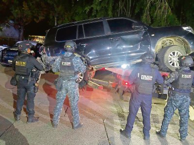 Elementos de la Policía estatal y de la Fuerza de Reacción Inmediata Pakal, observan la camioneta en la que fueron abatidos presuntos sicarios